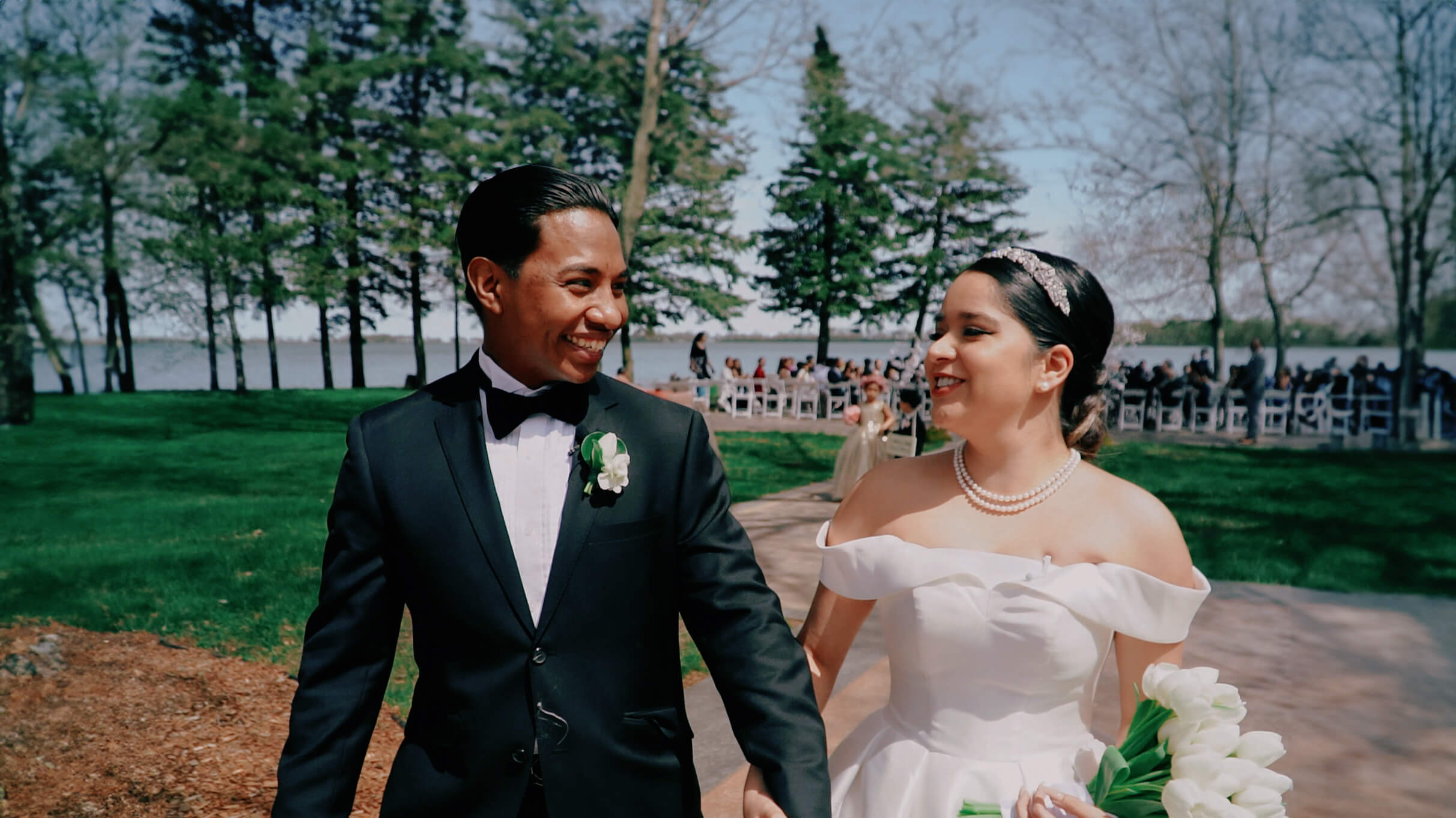 bride and groom walking down the lakeside aisle at round lake vineyards venue