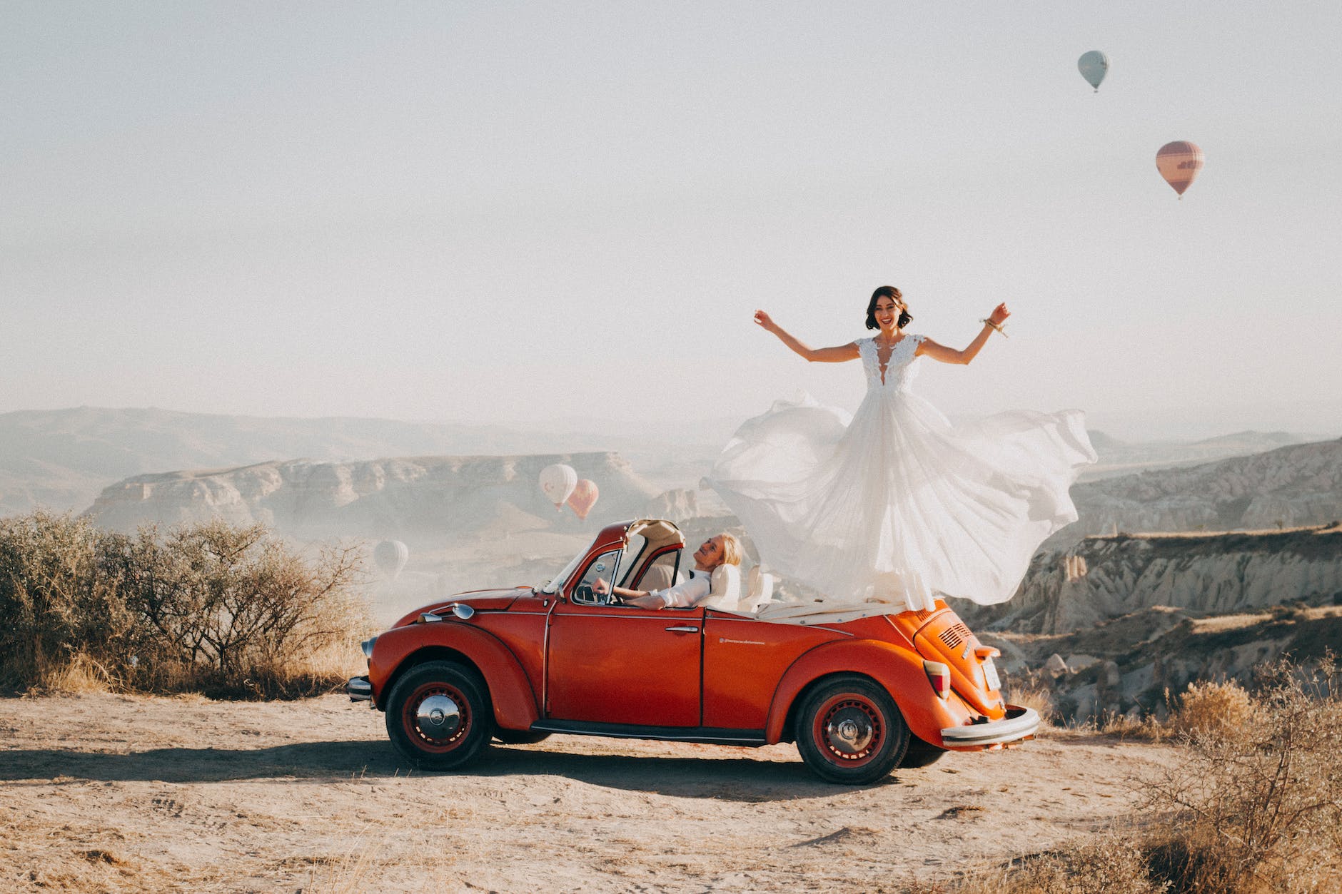 woman standing on volkswagen beetle