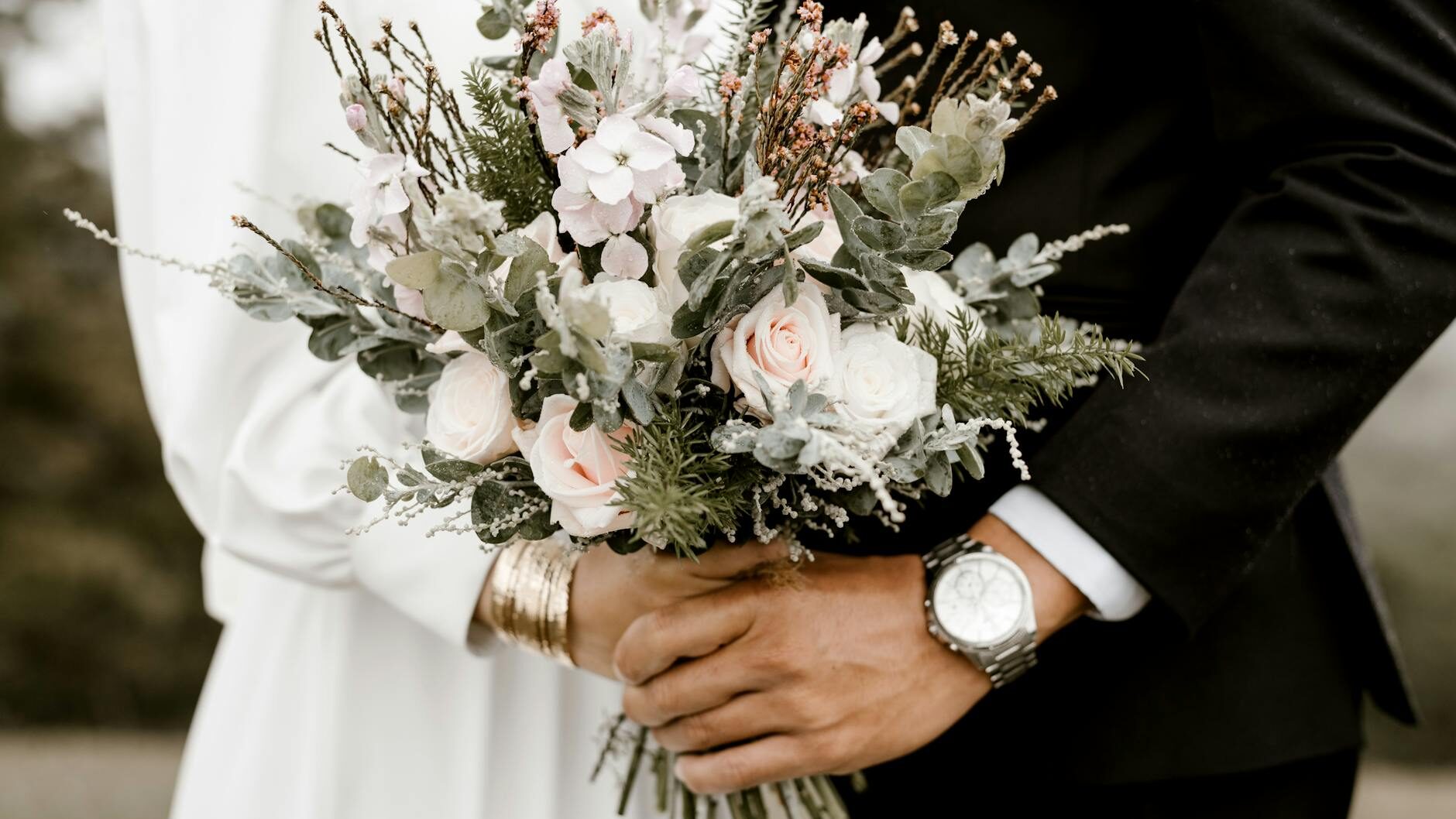 bridge and groom standing while holding flower bouquet