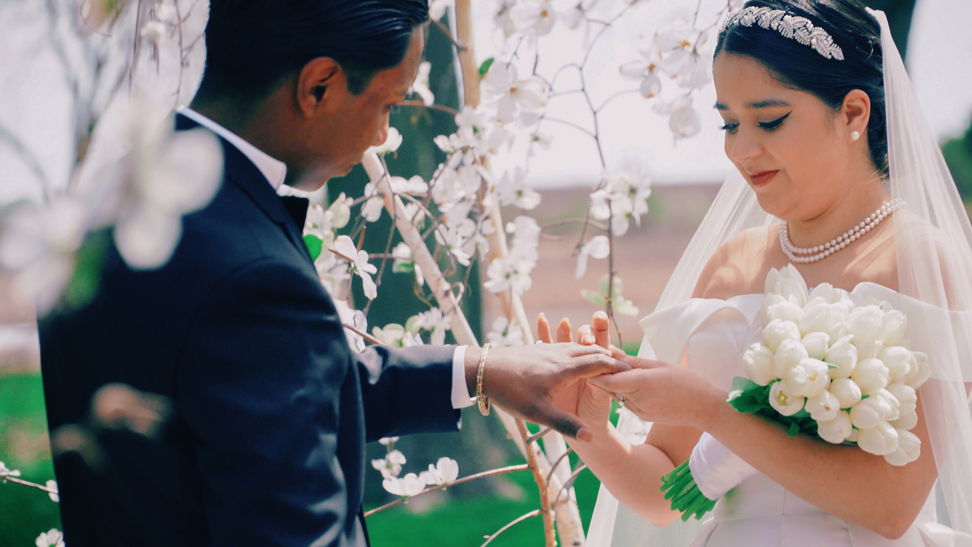 a groom putting a ring on a bride's finger at a waterfront wedding venue